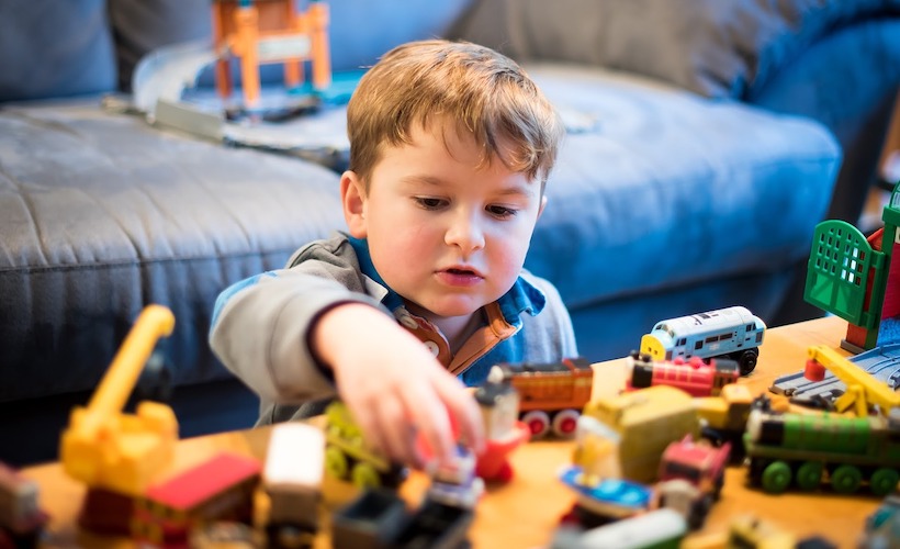 young boy playing with toys on coffee table