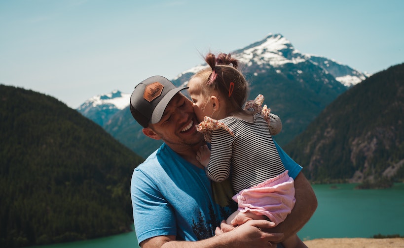 Dad holding baby on family vacation in mountains